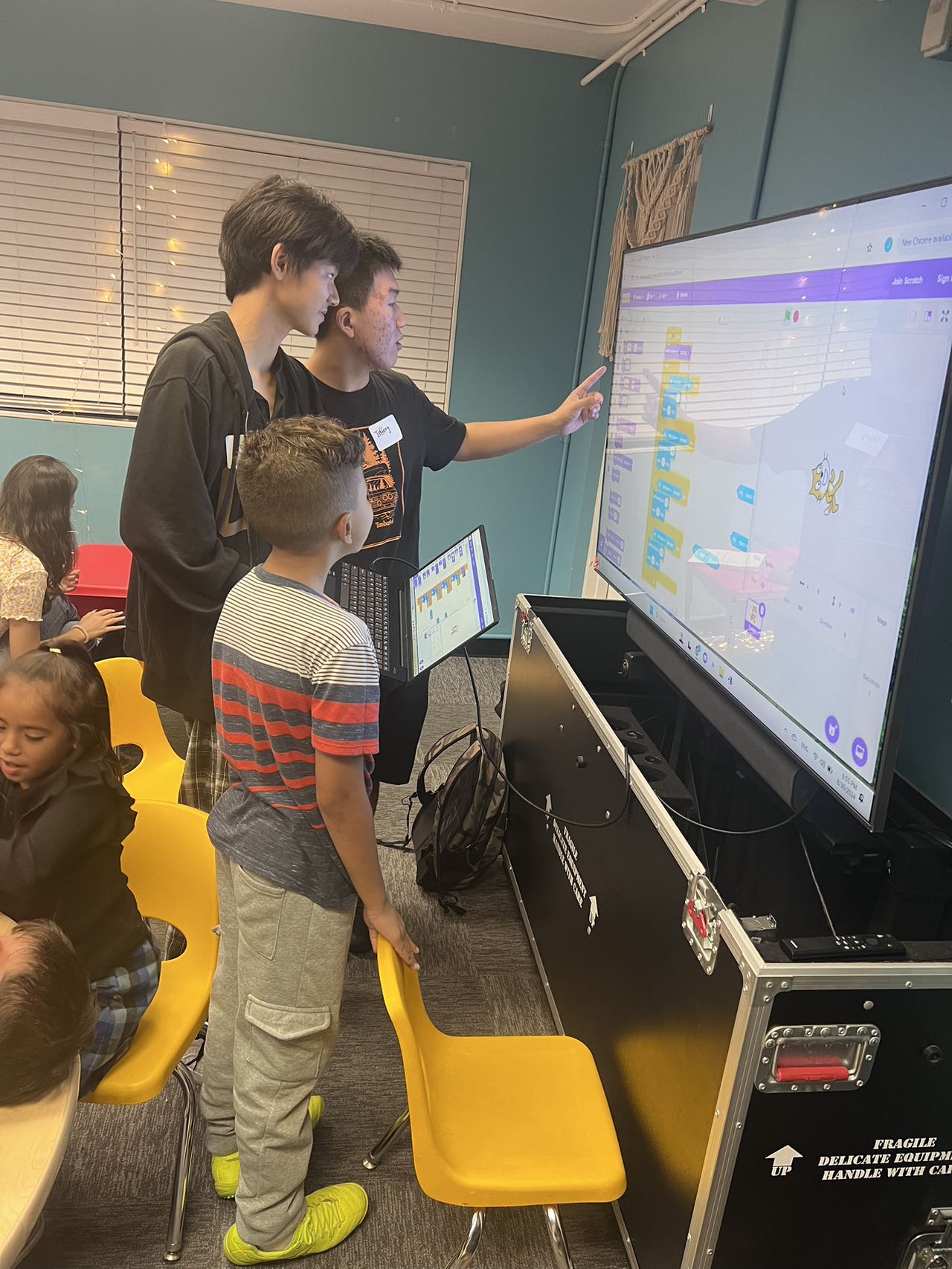 A group exploring Scratch programming on a classroom screen