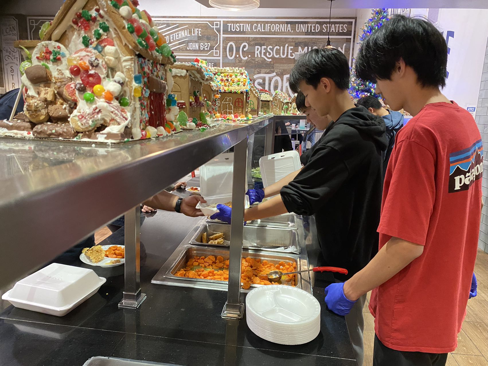 Volunteers serving food together at a meal counter