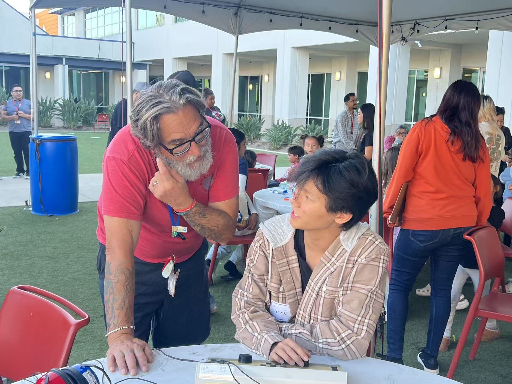 Two participants talking beside listening equipment at an outdoor community event